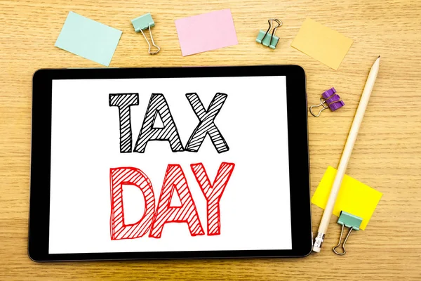 Σύνταξη κειμένου που δείχνει την ημέρα φόρου. Επιχειρηματική ιδέα για τη φορολογία εισοδήματος επιστροφή γραμμένο για το δισκίο laptop, ξύλινο υπόβαθρο με κολλώδη σημείωση και στυλό — Φωτογραφία Αρχείου