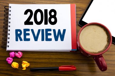 2018 inceleme gösterilen metin el yazısı. Geribildirim ilerleme yazılı not defteri not kağıdı, kalem kahve ve tablet ile office görünümünde eski siyah ahşap arka plan üzerinde yazılı iş kavramı