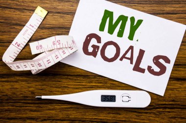 Kavramsal el My gol gösterilen metin resim yazısı yazma. İş kavramı liste planı için yapışkan not kağıdına ahşap arka plan üzerinde yazılı motivasyon için. Metre ve fitness konu için termometre.