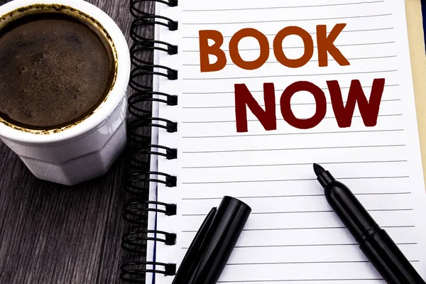 Writing text showing Book Now. Business concept for Reservation Buy Booking written on notebook book note paper on the wooden wood background. With coffee and black marker.