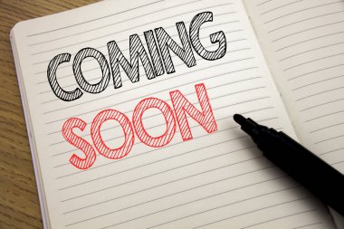 Coming Soon gösteren el yazısı duyuru metin. İş kavramı altında inşaat üstünde defter kitap arka plan üzerinde kopya alanı marker kalem ile yazılmış için