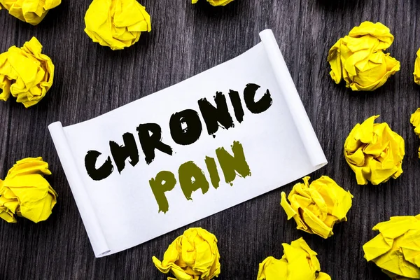 Writing text showing Chronic Pain. Business concept for Feeling Bad ill Care Written on sticky note notepad note notebook book wooden background with yellow sticky folded.