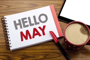 Merhaba ay olabilir gösteren el yazısı duyuru metin. Not defteri bir not kağıdına alanı office Oda kalem marker ile ahşap arka plan üzerinde gelen bahar ay yazılı için iş kavramı