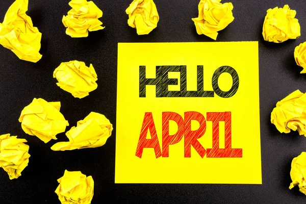 概念性手写文字显示您好的四月。春天欢迎的商业概念写在粘纸条纸上。背景上折叠的黄色文件 — 图库照片