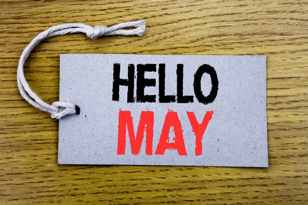 Texto conceptual escrito a mano que muestra Hello May Month. Concepto de negocio para el próximo mes de primavera escrito en papel de etiqueta de precio con espacio de copia en el fondo vintage de madera —  Fotos de Stock