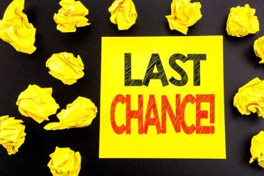 Kavramsal el son şans gösterilen metin yazma. İş kavramı için son tarih bitiş saati yapışkan not kağıdına yazılmış. Sarı kağıtları arka plan üzerinde katlanmış