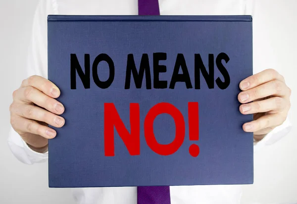 Writing text showing No Means No. Business concept for Stop Anti Rape Slogan written on book notebook paper holding by the man in suit blurred background.