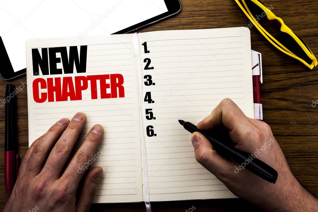 Word, writing New Chapter. Business concept for Starting New Future Life Written on book, wooden background with businessman hand, finger writing on the notebook.