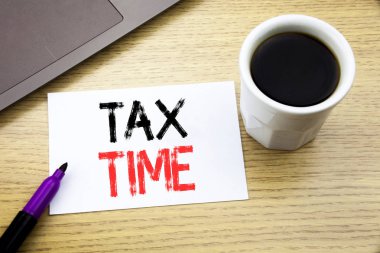 Vergi zamanı gösteren el yazısı duyuru metin. İş kavramı için vergilendirme Finans ilgili defter kitap dizüstü kahve ile ofis ahşap arka planda yazılı uyarı mektubu