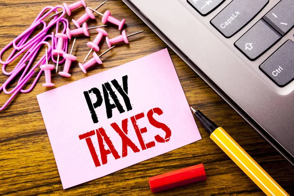 Handgeschreven tekst tonen betalen belastingen. Bedrijfsconcept voor belastingen Overtax Return geschreven op roze notitie papier op de houten achtergrond naast toetsenbord. Met rode pen. — Stockfoto