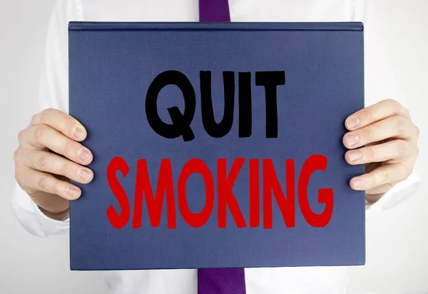 喫煙をやめるを示すテキストを書きます。スーツがぼやけて背景の男を持って本ノートブック紙に書かれたタバコの停止のためのビジネス コンセプト. — ストック写真