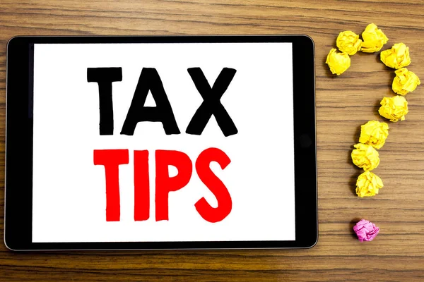 Writing text showing Tax Tips. Business concept for Tip Forn Taxes written on tablet computer on the wooden background with question mark made of folded paper.