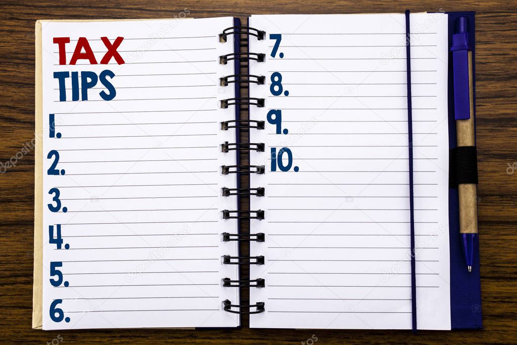 Writing text showing Tax Tips. Business concept for Tip Forn Taxes Written on notebook note paper, wooden background with pen and marker.