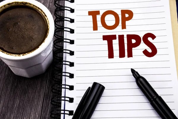 Writing text showing Top Tips. Business concept for Expert Tip Guidance written on notebook book note paper on the wooden wood background. With coffee and black marker.