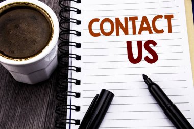 Bize ulaşın gösterilen metin yazma. Ahşap ahşap arka plan defter kitap bir not kağıdına yazılı müşteri desteği iş kavramı. Kahve ve siyah marker ile.