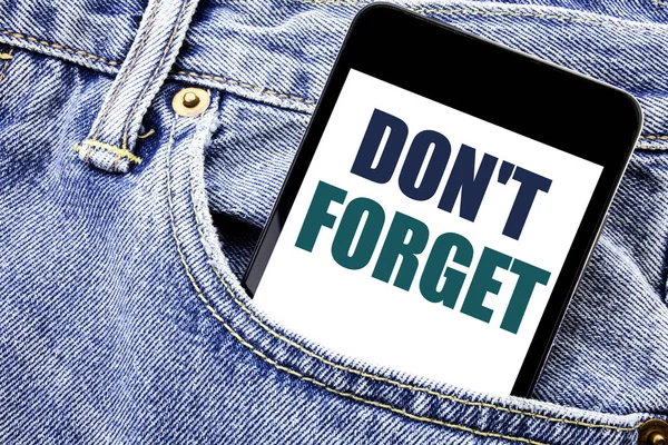 Conceptual hand writing text caption inspiration showing Do Not Forget. Business concept for Don t memory Remider Written phone mobile phone, cellphone placed in the man front jeans pocket.