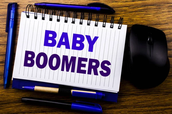 Handwritten text showing Baby Boomers. Business concept for Demographic Generation written on notebook book note paper on the wooden background. Blue word letters. Next to mouse. — Stock Photo, Image