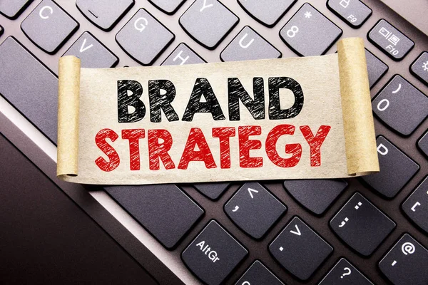 Marka stratejisi gösterilen metin resim yazısı ilham yazma el. İş kavramı pazarlama fikir karanlık klavye arka plan üzerinde yapışkan not kağıt üzerinde yazılı planı için.