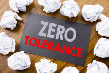Sıfır tolerans gösterilen metin resim yazısı yazma el. İlke için yapışkan not kağıdına katlanmış kağıt anlam düşünce ile ahşap arka plan üzerinde yazılı ceza için iş kavramı