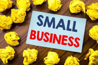 Kavramsal el küçük işletme gösterilen metin ilham yazma. Strateji ahşap arka plan üzerinde yapışkan not kağıdına katlanmış sarı kağıt üzerinde yazılı yönetimi için iş kavramı