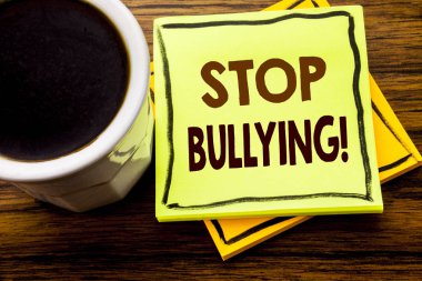 Durdurmak zorbalık gösteren el yazısı metin. İş kavramı önleme sorun ahşap tahta arka plan ile kahve fincanı yapışkan not kağıdına yazılı kabadayı için