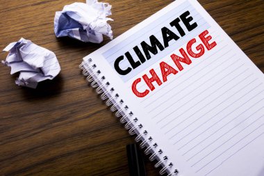 İklim değişikliği gösteren metin yazma. İş kavramı küresel gezegen ısınma defter not defteri bir not kağıdına katlanmış kağıt anlam düşünce fikir için ile ahşap arka plan üzerinde yazılı
