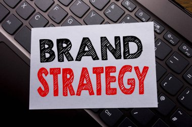 Word, marka stratejisi yazma. İş kavramı pazarlama fikir karanlık klavye arka plan üzerinde yapışkan not kağıt üzerinde yazılı planı için.