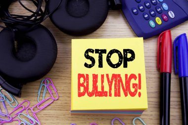 Word, durdurmak zorbalık yazma. İş kavramı önleme sorun ahşap arka plan üzerinde yapışkan not kağıt üzerinde yazılı kabadayı için. Hesap makinesi ve kalem marker ve kulaklık ile