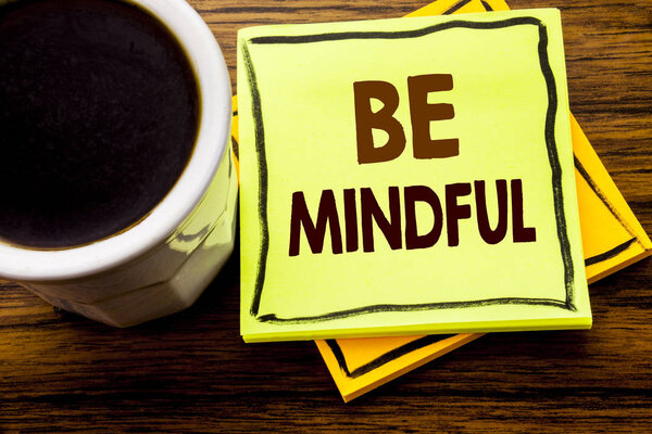 Handwritten text showing Be Mindful. Business concept for Mindfulness Healthy Spirit written on sticky note paper on the wooden wood background with coffee cup