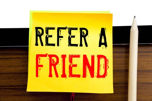 Tekstoverskrift for hånd inspirert av Refer A Friend. Forretningskonsept for henvisning Markedsføring på papir med klistremerke på bakgrunn av tre og nettbrett . – stockfoto