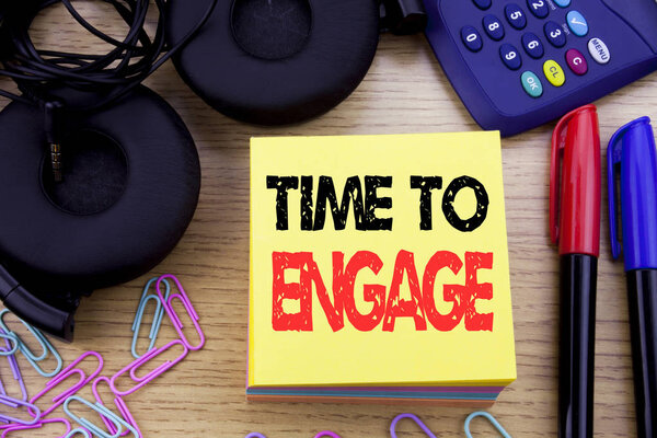 Слова, написание Time To Engage. Бизнес-концепция проекта написана на бумаге на деревянном фоне. С калькулятором, маркером и наушниками
