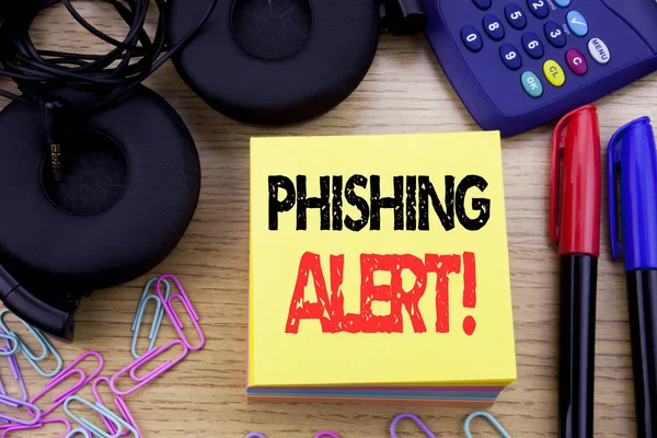 Wort, das Phishing-Alarm schreibt. Geschäftskonzept für Betrugswarnungen auf klebrigem Zettelpapier auf dem hölzernen Hintergrund. mit Taschenrechner und Kugelschreiber und Kopfhörer — Stockfoto
