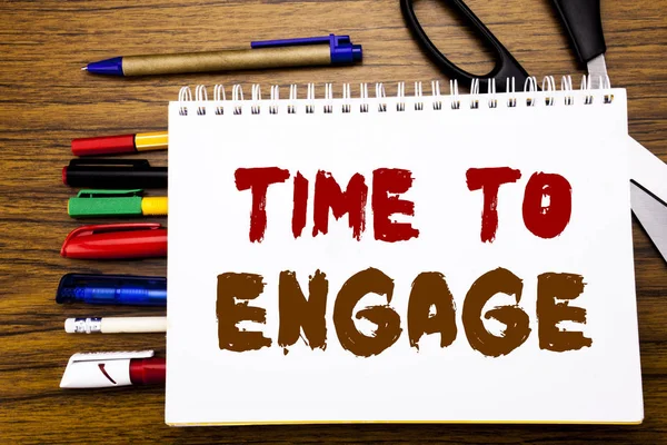 Palavra, escrevendo Time To Engage. Conceito de negócio para envolvimento Engajamento Escrito em notebook, fundo de madeira com equipamento de escritório como canetas tesoura marcador colorido — Fotografia de Stock