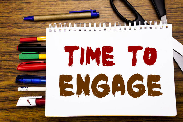 Слова, написание Time To Engage. Бизнес-концепция для вовлечения Записано на ноутбуке, деревянный фон с офисным оборудованием, как ручки ножницы красочный маркер
  