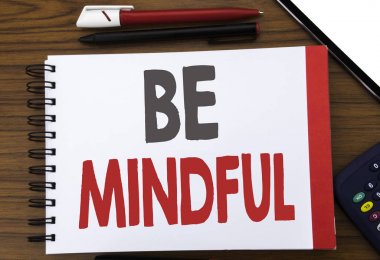 Var olmak dikkatli gösteren el yazısı metin. Mindfulness sağlıklı ruh yazılı not defteri Not kağıt üzerinde ofis görünümünde ahşap arka planı için kalem marker hesap makinesi ile yazma iş kavramı