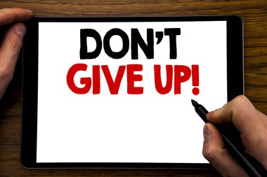 Don t Give Up gösteren el yazısı duyuru metin. İş kavramı motivasyon belirlenmesi, yazılı tablet laptop, işadamı el, parmak PC'de yazma ile ahşap arka plan.