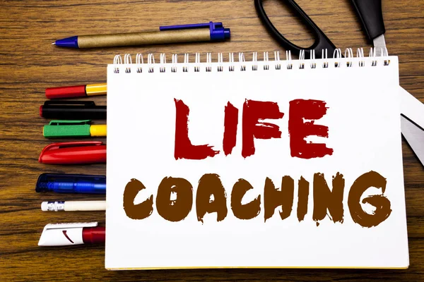 Palavra, escrever Life Coaching. Conceito de negócio para Personal Coach Ajuda Escrito em notebook, fundo de madeira com equipamento de escritório como canetas tesoura marcador colorido — Fotografia de Stock