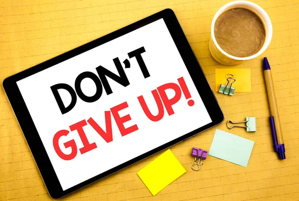 Conceptual hand writing text caption showing Don t Give Up. Business concept for Motivation Determination, Written on tablet laptop, wooden background with sticky note, coffee and pen — Stock Photo, Image