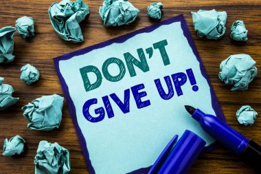 Don t Give Up gösterilen metin yazma. İş kavramı motivasyon tayini için yapışkan not kağıdı, marker ile ahşap arka plan üzerinde yazılı sarı kağıt anlam düşünme katlanmış.