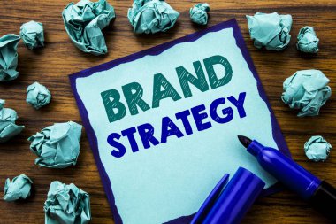 Marka stratejisi gösterilen metin yazma. Yapışkan Not kağıt üzerinde iş kavramı pazarlama fikir yazılmış planı için marker ile ahşap arka plan sarı kağıt anlam düşünme katlanmış.