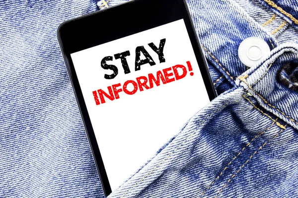 Hand writing text caption inspiration showing Stay Informed. Business concept for Be Awareness Or Awake Written phone mobile phone, cellphone placed in the man front jeans pocket.
