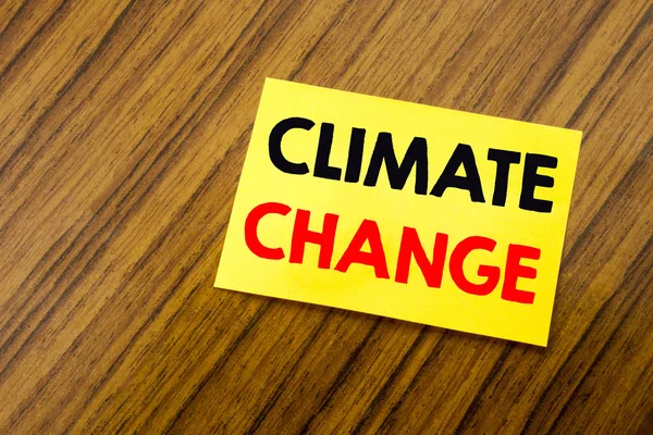 Hand writing text caption inspiration showing Climate Change. Business concept for Global Planet Warming written on sticky note paper on the wooden keyboard background. Empty table. — Stock Photo, Image