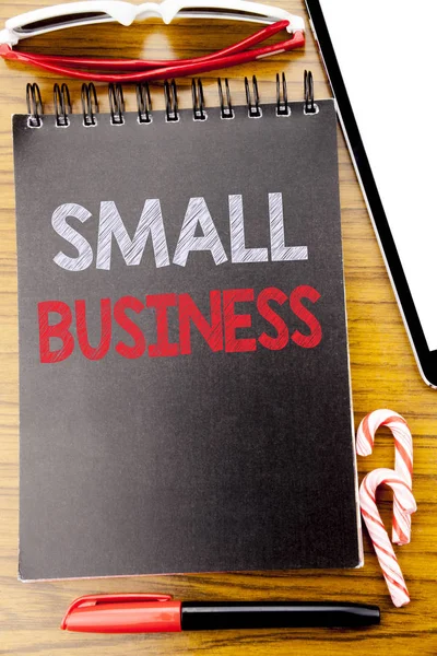 Slovo, psaní malých firem. Obchodní koncept pro strategie řízení psaný na poznámkového bloku knihy, dřevěné pozadí s lepivými sluneční brýle a červené pero — Stock fotografie