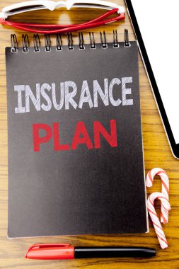 Word, sigorta planı yazma. Defter kitap, yapışkan güneş gözlüğü ve kırmızı kalem ile ahşap arka plan üzerinde sağlık hayat sigortalının yazılı için iş kavramı