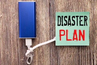 Handwritten text caption showing Disaster Plan. Business concept writing for Emergency Recovery written on sticky note with copy space old wood wooden background with power bank clipart