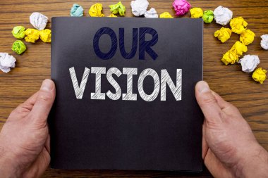 Word, bizim vizyon yazma. İş kavramı için pazarlama stratejisi vizyon not defteri defter kitap adam işadamı el ve parmak ile ahşap ahşap arka plan üzerinde yazılı.