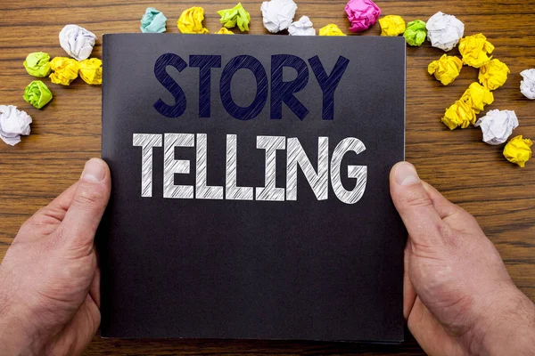 Parola, scrivere Storytelling. Business concept per Teller Story Messaggio scritto su taccuino taccuino libro sullo sfondo in legno con uomo d'affari mano e dito . — Foto Stock
