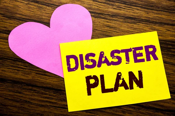 Hand writing text caption inspiration showing Disaster Plan. Business concept for Emergency Recovery written on sticky note paper, wooden wood background. With pink heart meaning love adoration.