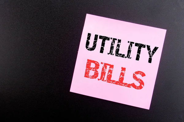 Word, writing Utility Bills. Business concept for Money Bill Payment written on sticky note, black background with copy space