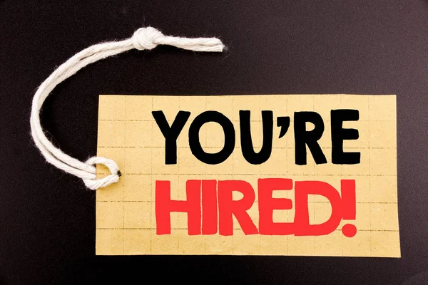 J'écris "Vous êtes embauché". Concept d'entreprise pour la vente en ligne Embauche Employé Travailleur écrit sur papier étiquette de prix sur le fond noir vintage . — Photo